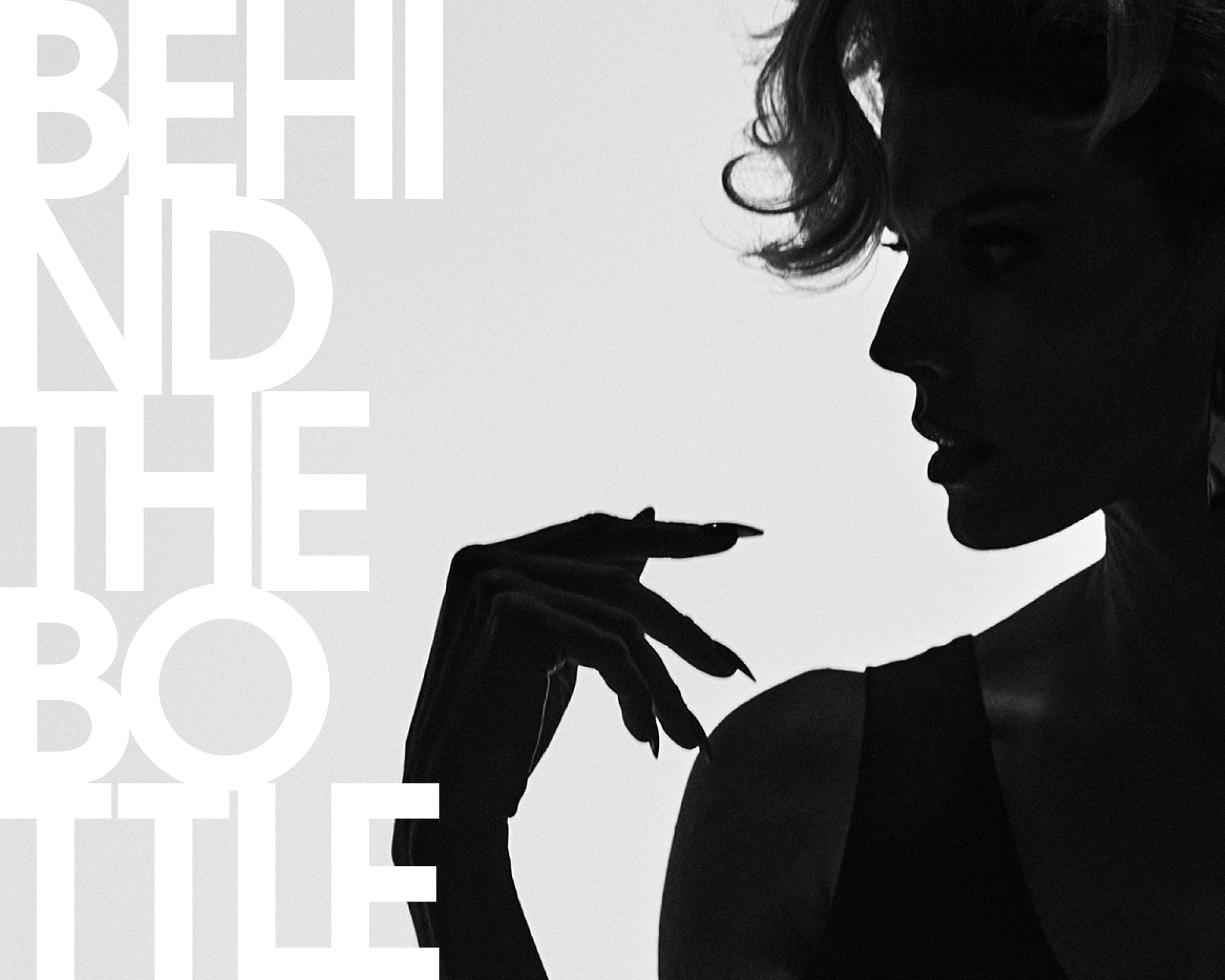 A high-contrast black and white editorial photograph of a woman in profile, silhouetted against a light background, with large white text on the left reading 'BEHIND THE BOTTLE'.