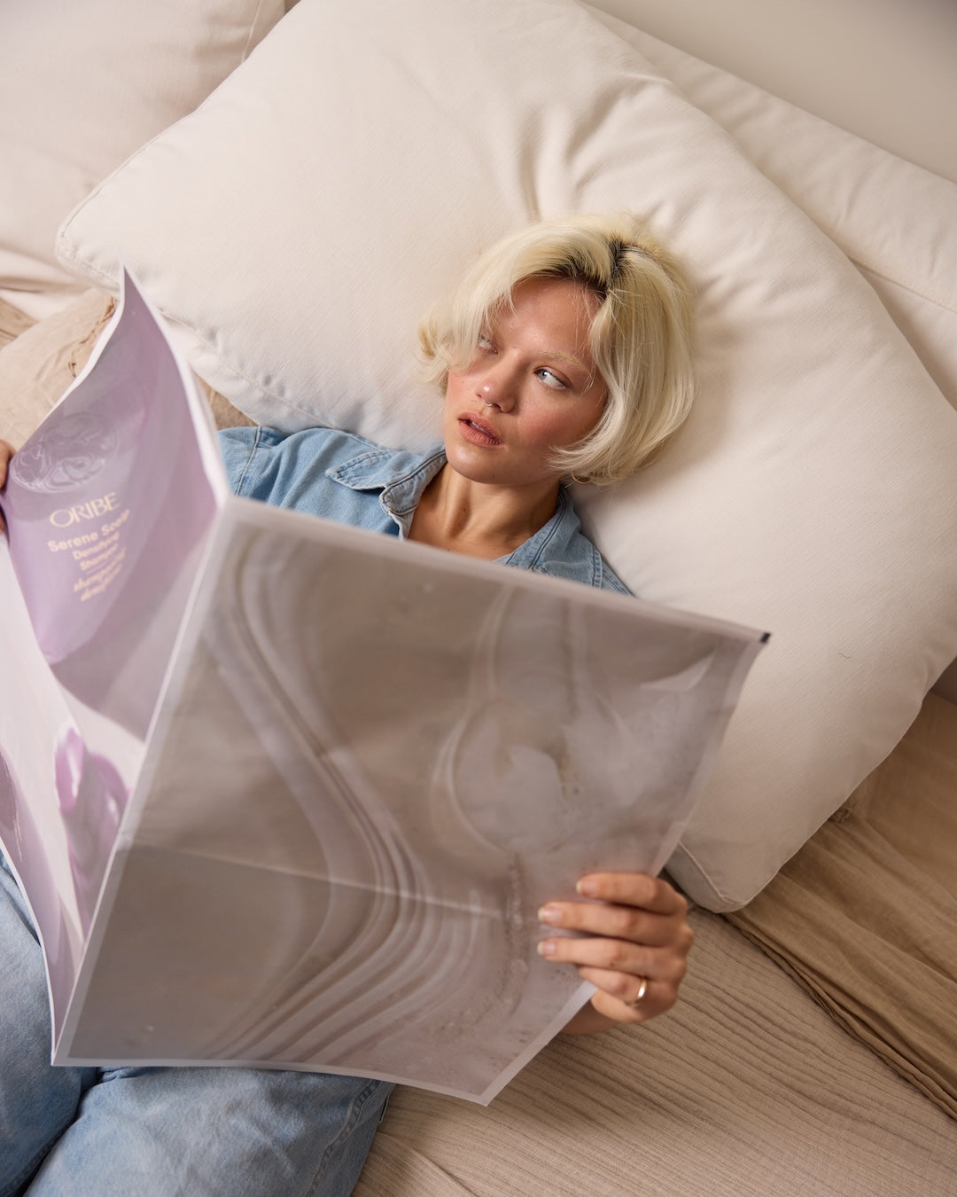 woman holding newspaper with oribe imagery on it